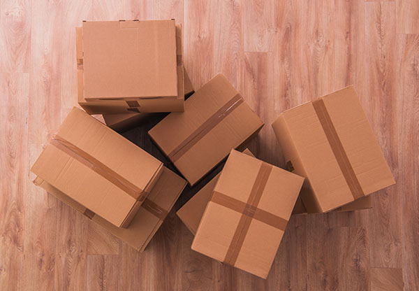 Moving Boxes on Empty Wooden Flooring. Top View.