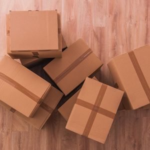 Moving Boxes on Empty Wooden Flooring. Top View.